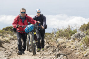 Pushing mountainbikes at Mount Kilimanjaro, Tanzania.